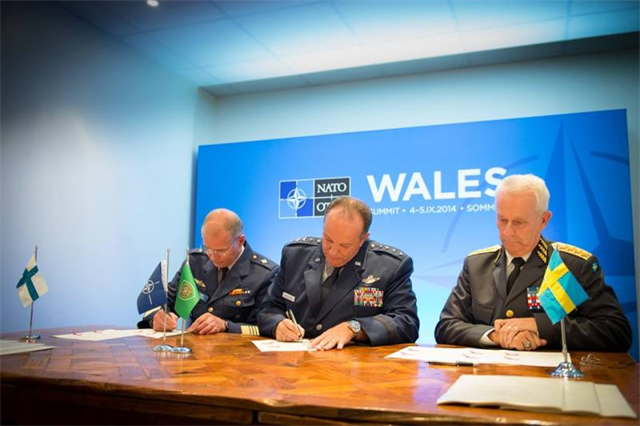 Kenr Jarmo Lindberg (vas), kenr Phil Breedlove (kesk), Naton Euroopan-joukkojen komentaja, ja kenr Sverker Göranson, Ruotsin asevoimien ylipäällikkö, allekirjoittavat Host Nation Support -sopimuksen Naton huippukokouksessa Newportissa, . Kuva: SHAPE photo, courtesy Edouard Bocquet, SHAPE Public Affairs Office